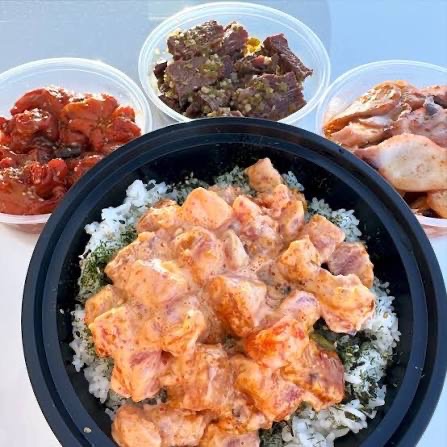 Poke Express spicy mayo salmon bowl surrounded by side poke containers